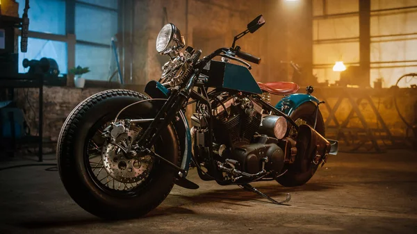 Moto Bobber personalizado de pie en un taller creativo auténtico. Motocicleta de estilo vintage bajo luz cálida de la lámpara en un garaje . — Foto de Stock