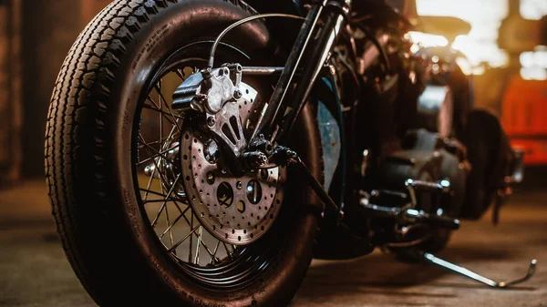 Macro Close Up Wheel Details eines Custom Bobber Motorrads, das in einer authentischen Kreativwerkstatt steht. Verchromte Motorradspeichen und Scheibenbremsen hautnah. — Stockfoto
