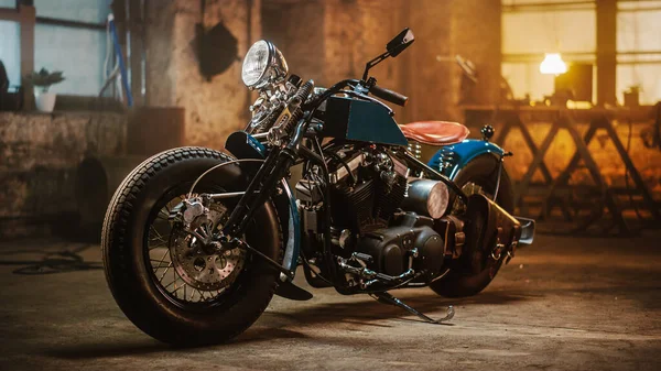 Moto Bobber personalizado de pie en un taller creativo auténtico. Motocicleta de estilo vintage bajo luz cálida de la lámpara en un garaje . — Foto de Stock