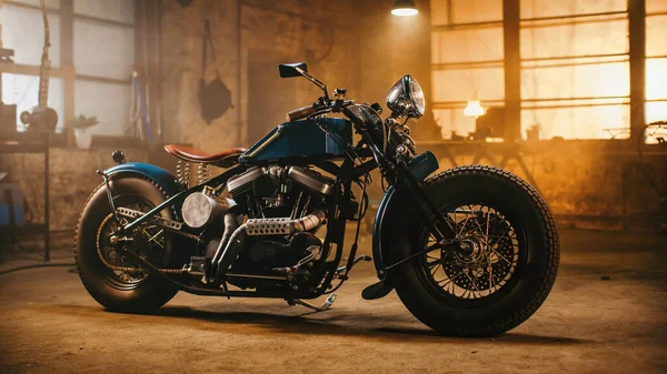 Moto Bobber personnalisée debout dans un atelier créatif authentique. Moto de style vintage sous la lumière chaude de lampe dans un garage. — Photo