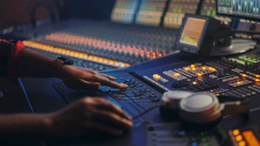 Music Creator, Musician, Artist Works in the Music Record Studio, Surface Control Conk Equalizer Mixer kullanıyor. Buttons, Faders, Sliders to Broadcast, Record, Hit Song 'u çal. Yakından Ellere Odaklan