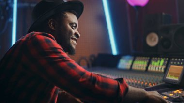 Müzik Kayıt Stüdyosunda Çalışan Ses Mühendisinin Portresi, Karıştırma Kurulu Oluşturur Modern Ses. Kontrol masasında çalışan başarılı bir siyahi sanatçı müzisyen. Eğlenmek, gülümsemek..
