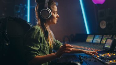 Müzik Kayıt Stüdyosunda Güzel Kadın Sanatçı Müzisyeninin Portresi, Kulaklık Kullanıyor. Başarılı Kadın Ses Mühendisi Karıştırma Kurulu Kullanıyor Modern Şarkı Oluştur.