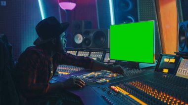 Müzik Kayıt Stüdyosunda Çalışan Tarz Ses Yapımcısı, Yeşil Ekran Kroma Anahtar Bilgisayar Ekranı, Karıştırıcı Masası Eşgüdümleyicisi ve Yeni Hit Şarkı Oluşturmak İçin Kontrol Masası Kullanır. Yaratıcı Siyah Sanatçı Müzisyen