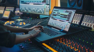 Modern Müzik Kayıt Stüdyosu Kontrol Masası, Dijital Ses İşlem Yazılımının Dizüstü Bilgisayar Ekran Arayüzünü Gösteren Kullanıcı Arayüzü Dengeleyici, Karıştırıcı ve Profesyonel Ekipman. Faders, Sliders. Kayıt. Yakın plan.