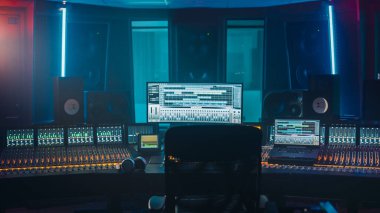 Bilgisayar Ekranı ile Modern Müzik Kayıt Stüdyosu Kontrol Masasının Çekimi DAW Yazılım Kullanıcı Arayüzü 'nü Song Playing ile gösterdi. Eşitleyici, Karıştırıcı ve diğer Profesyonel Eşitleyici.