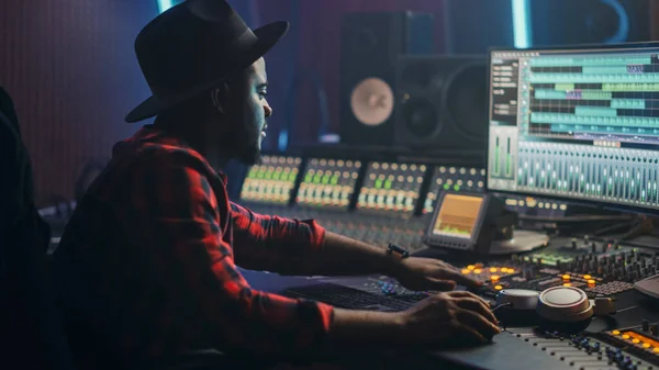 Energetic Male Audio Engineer Producer Werken in Music Recording Studio, Mixing Tracks op Control Desk en Software om Hit Song Track te maken. Kunstenaar muzikant betreedt zijn atelier op zit aan de werktafel — Stockfoto