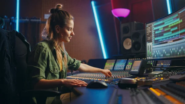 Vacker, stilig kvinnlig ljudtekniker och producent som arbetar i musikinspelningsstudio, använder Mixing Board och programvara för att skapa cool sång. Kreativ flicka konstnär musiker arbetar för att producera ny sång — Stockfoto