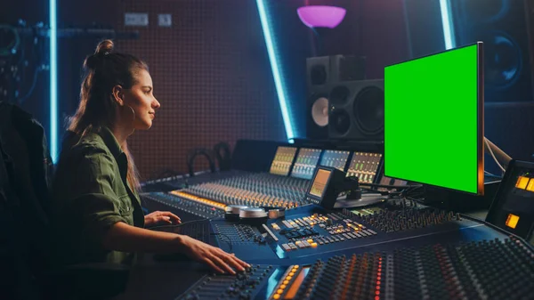 Retrato de una productora de sonido femenina con estilo que trabaja en Music Record Studio, utiliza una computadora de pantalla verde, un tablero mezclador y un escritorio de control para crear una nueva canción . — Foto de Stock