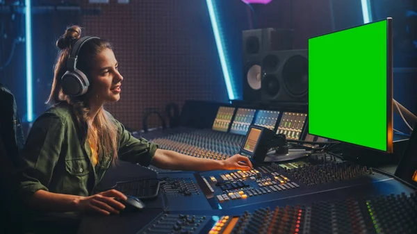 Productora de sonido femenina con estilo que trabaja en Music Record Studio, utiliza auriculares, pantalla verde, tablero mezclador, escritorio de control para crear nueva canción. Artista creativo Músico . — Foto de Stock