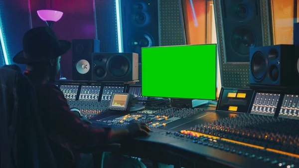 Stylish Audio Engineer Producer Working in Music Record Studio, Uses Green Screen Chroma key Computer Display, Mixer Board Equalizer and Control Desk to Create New Hit Song. Black Artist Musician — Stock Photo, Image