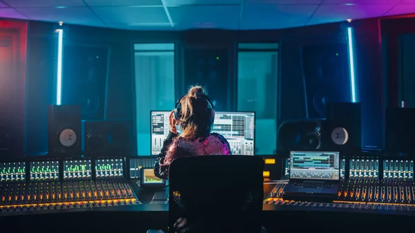 Stylowy artysta, muzyk, inżynier dźwięku, producent odbywa się w jego stanowisku sterowania w studiu nagraniowym, używa ekranu komputera pokazać interfejs użytkownika oprogramowania DAW z odtwarzania piosenek. Powrót Widok — Zdjęcie stockowe