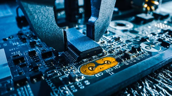 Macro close-up da máquina da fábrica no trabalho: placa de circuito impresso sendo montada com braço robótico, tecnologia montada na superfície conectando microchips, processador de CPU para a placa-mãe . — Fotografia de Stock