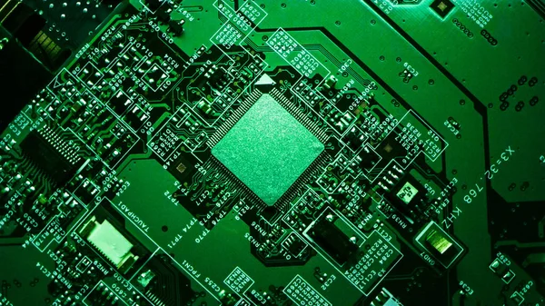 Macro Primer plano de microchip, procesador de CPU en placa de circuito impreso verde, placa base de la computadora con componentes dentro del dispositivo electrónico, parte de la supercomputadora. Lit by Green Light . —  Fotos de Stock
