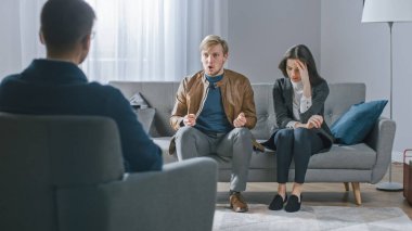 Psikoterapistle danışmanlık seansında genç bir çift. Terapist Not Alırken Geçmişe Bakış: Öfkeli Erkek Arkadaş Öfkeleniyor. Aile İçi Şiddet