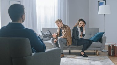 Psikoterapistle danışmanlık seansında olan genç bir çift. Terapistin Not Almasına Bakış: Analizci Koltukta Sırtüstü Oturan Gençler, Tartışma, Kavga, İlişki Sorunları