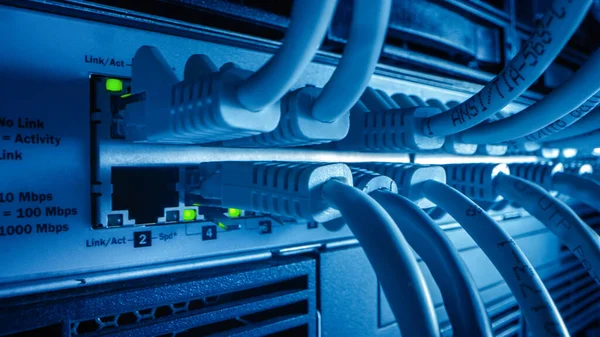 Detailní záběr makra: Ethernet kabely připojené k portům směrovače s blikajícími světly. Telekomunikační konektory zařízení RJ45 zapojeny do rozbočovačů modemu. Zabezpečit datové centrum. — Stock fotografie