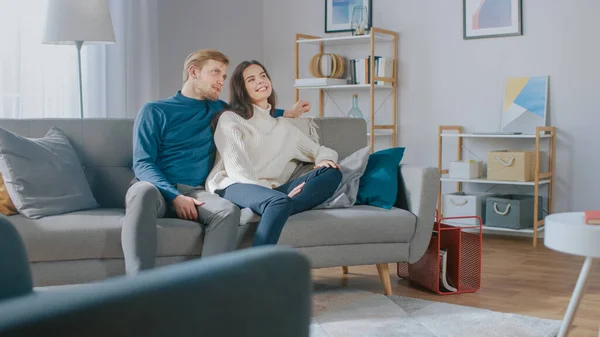 拡張現実使用のテンプレート:若いカップルは、リビングルームで視聴するメディアコンテンツのスワイプと選択に拡張現実を使用します. — ストック写真