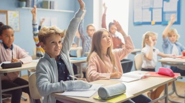 Öğretmen, Parlak Çocuklar Sınıfı 'na Dersi Açıklıyor, Sorular Soruyor. Çok Irklı Öğrenen Çocuklar İlköğretim Okulu Grubunda Cevap Vermek İçin Ellerinizi Kaldırın.