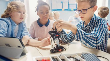 İlköğretim Okulu Robot Sınıfı: Çeşitli Çocuklar Robot Yapıyor ve Birlikte Programlıyor, Konuşuyor ve Takım Olarak Çalışıyor. Yazılım Öğrenen Çocuklar Tasarım ve Yaratıcı Robot Mühendisliği