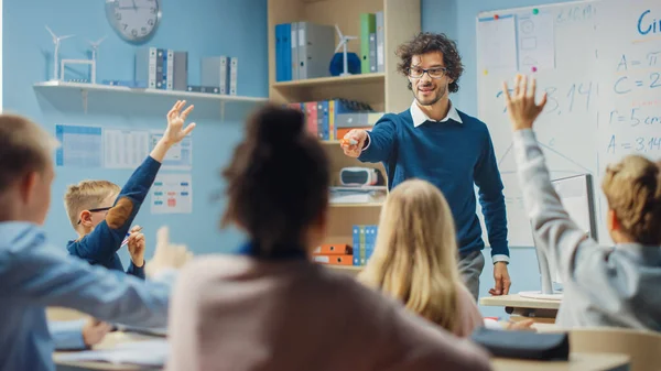 Teacher Explains Lesson to a Diverse Classroom of Bright Children. In Elementary School with Group of Bright Multiethnic Kids Learning Science, Raising Hands with an Answer. — Stock Photo, Image