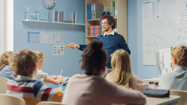 Professor Entusiástico Explica Lição a uma Sala de Aula Cheia de Crianças Brilhantes e Diversas, Ensina Geometria, Matemática. Na Escola Primária Grupo de Crianças Multiétnicas Brilhantes Aprendendo Ciência, Pensamento Criativo — Fotografia de Stock