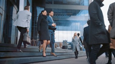 Çeşitli ve Çok Kültürlü Büro Yöneticileri ve İş Adamları Sabah İşe İşe Dönüş ya da Ayağında Güneşli Bir Gün Ofisi 'nden. Kadın ve Erkek Ofisten dönerken konuşuyor ve gülümsüyor.
