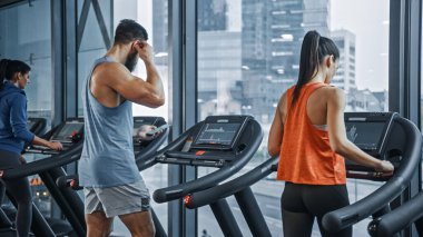 Koşu bandında koşan, spor yapan atletik insanlar. Modern Spor Salonu 'nda Atletik ve Kaslı Kadınlar ve Erkekler Aktif Eğitimde. Spor İnsanlar Antrenmanı. Arka Görünüm Görüntüsü