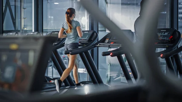 Athletic Sports Women Running on a Treadmills. Energetic Fit Women Athletes Training in the Gym. Female Only Fitness Club for Workout and Training. Back View — Stock Photo, Image