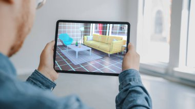 Dekorasyon Dairesi: Man Holding Digital Tablet with AR Interior Design Software Choes 3D Mobilya Evi. Man, Oturma Odası için Masa 'yı seçiyor. 3B Render ile Omuz Ekran Görüntüsü