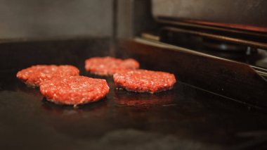 Lezzetli Yakın plan Et Patty Izgarada Hazırlanıyor. Taze Biftek Sıcak Benzin veya Elektrikli Izgarada Kızartıldı. Aşçı, Taze Kıymalı Taze Et 'ten Burger için bir Patty çeşniliyor..