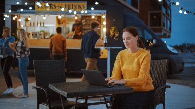 Güzel Esmer Kadın, bir sokak yemekhanesinde bir masada otururken dizüstü bilgisayarda çalışıyor. İnternet ya da Sosyal Medya 'yı tarıyor, Durum Güncellemesi gönderiyor. Emri Bekliyorum..