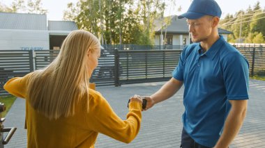 Güzel Genç Kadın Karton Paket Paketini Veren Teslimatçıyla Tanışıyor, Elektronik İmza Posta Cihazı İmzalıyor. Varoş Mahallesi 'nde Kurye Paketi Teslim Ediyor