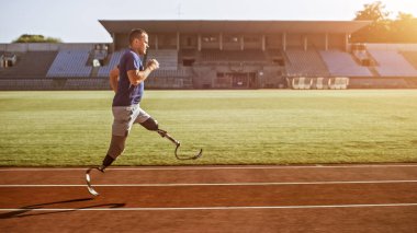 Protez Koşu Bıçaklı Engelli Atletik Fit Adam Sunny Afternoon 'da bir stadyumda antrenman yapıyor. Ampütasyon Koşucusu Stadyum Pisti 'nde koşuyor. Motivasyon Sporu Çekimi.