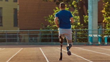 Protez Koşu Bıçaklı Engelli Atletik Fit Adam Sunny Afternoon 'da Açık Hava Stadyumu' nda antrenman yapıyor. Ampütasyon Koşucusu Stadyum Pisti 'nde koşuyor. Motivasyon Sporu Çekimi.