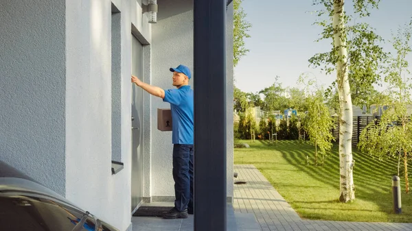 Leverans Man House and Delivers Kartong paket till ett stort vackert hus i förorten. I det söta förortskvarteret. Sidovy Skott — Stockfoto