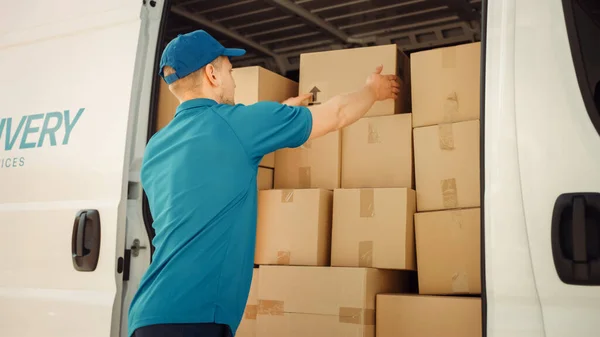 Courier haalt kartonnen doos pakket van geopende bestelwagen naar postpakket leveren aan de klant. — Stockfoto