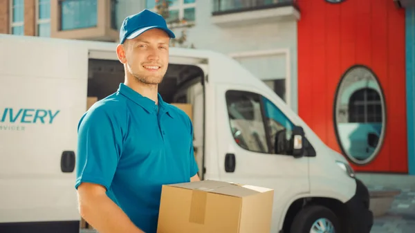 Handsome Courier neemt kartonnen doos pakket uit de levering Van Walks Door Modern Stijlvolle Business District. Koerier op weg naar levering postpakket aan een klant — Stockfoto