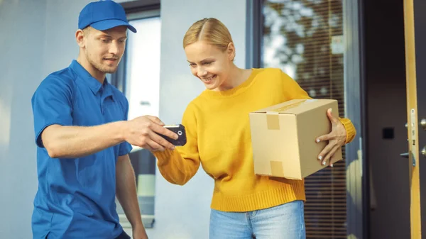 Belle jeune femme rencontre l'homme de livraison qui donne son paquet de boîte en carton, elle signe un dispositif de PDD de signature électronique. Courrier Livraison de colis dans le quartier de banlieue. — Photo