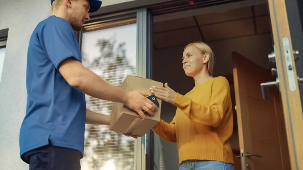 Beautiful Young Woman Opens Doors of Her House and Meets Delivery Man who Gives Her Cardboard Box Postal Package, She Signs Electronic Signature POD Device.