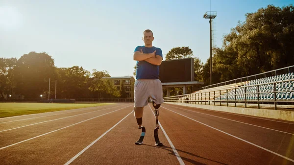 Athletic Disabled Fit Man with Prosthetic Running Blades está posando con brazos cruzados en un estadio al aire libre en una tarde soleada. Amputado corredor de pie en una pista. Shot deportivo motivacional . —  Fotos de Stock