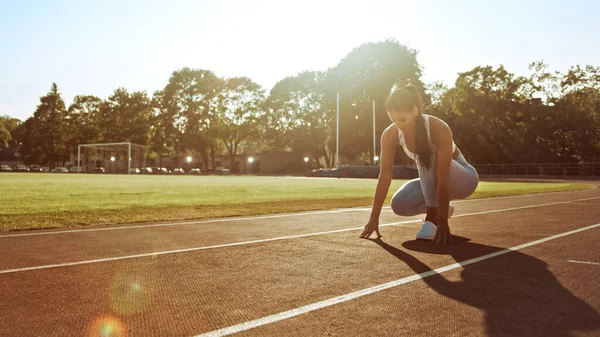 Beautiful Fitness Donna in Light Blue Athletic Top e Leggings sta iniziando una corsa di Sprint in uno stadio all'aperto. Sta correndo in una calda giornata estiva. Atleta che fa la sua pratica sportiva. — Foto Stock