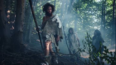Tribe of Hunter-Gatherers Wearing Animal Skin Holding Stone Tipped Tools, Explore Prehistoric Forest in a Hunt for Animal Prey. Neanderthal Family Hunting in the Jungle or Migrating for Better Land clipart
