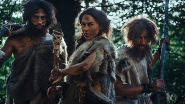 Dişi Lider ve İki İlkel Mağara Adamı Düşman 'ı Taş Deviren Mızrak, Çığlık, Tarih Öncesi Zamanlarda Mağaralarını ve Bölgelerini Savunmakla Tehdit Ettiler. Neandertaller Homo Sapiens Kabilesi