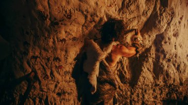 Hayvan Derisi Giyen İlkel Tarih Öncesi Neandertal Geceleri Duvarlara Hayvanlar ve Soyutlar Çizer. Petrogliflerle İlk Mağara Sanatı, Ateşle aydınlatılan Kaya Resimleri. Arka Görünüm