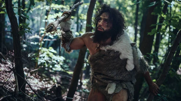 Close-up Portrait of Primeval Caveman Wearing Animal Skin and Fur Hunting with a Stone Tipped Spear in the Prehistoric Forest. Prehistoric Neanderthal Hunter Ready to Throw Spear in the Jungle — Stock Photo, Image