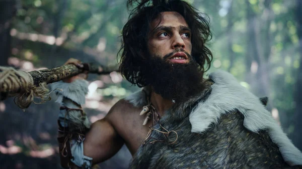 Portrait of Primeval Caveman Wearing Animal Skin and Fur Hunting with a Stone Tipped Spear in the Prehistoric Forest. Prehistoric Neanderthal Screaming, Threatening and Attacking — Stock Photo, Image