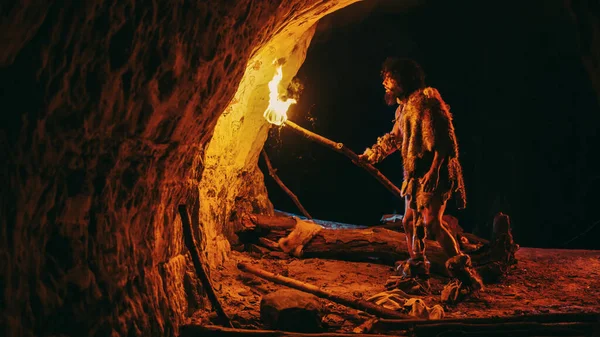 Первинна печера Caveman надягає шкіру тварин Exploring Cave At Night, Holding Torch with Fire Looking at Drawings on the Walls at Night. Cave Art with Petroglyphs, Rock Paintings Сторона зору — стокове фото