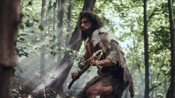 Primeval Caveman draagt Animal Skin Holds Stone Tipped Spear Looks around, verkent het prehistorische bos in een jacht naar dierlijke prooi. Neanderthaler gaat jagen in de Jungle — Stockfoto