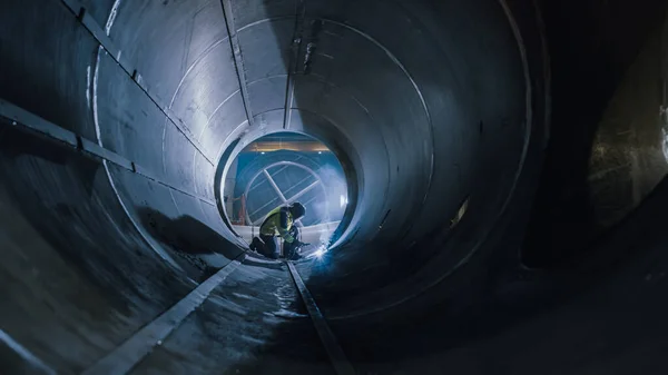 Lavoratore dell'industria pesante professionale che indossa la saldatura del casco all'interno del tubo del gas e dell'olio. Costruzione dell'oleodotto, del gas naturale e dei combustibili. Fabbrica manifatturiera industriale — Foto Stock